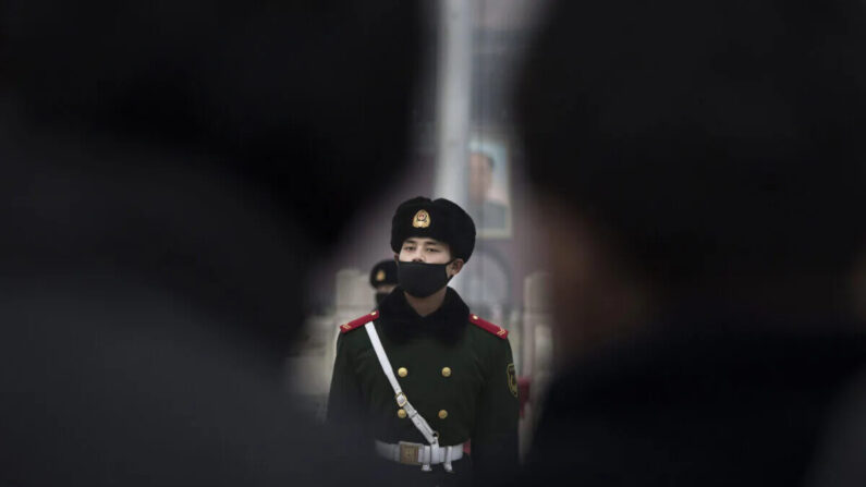 Un oficial de policía paramilitar chino usa una máscara para protegerse contra la contaminación, mientras marcha durante la niebla con humo en la plaza de Tiananmen, en Beijing, China, el 9 de diciembre de 2015. (Kevin Frayer/Getty Images)
