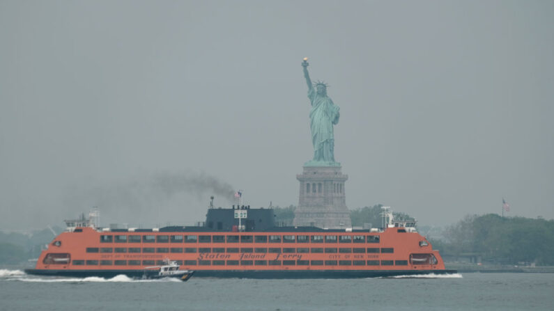 El transbordador de Staten Island pasa junto a la Estatua de la Libertad en una mañana brumosa provocada por los incendios forestales de Canadá el 6 de junio de 2023 en Nueva York. (Spencer Platt/Getty Images)