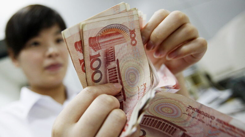 Una empleada bancaria china cuenta pilas de billetes de 100 yuanes en un banco de Huaibei, en la provincia oriental china de Anhui, en esta foto de archivo tomada el 4 de agosto de 2010. (STR/AFP/Getty Images)