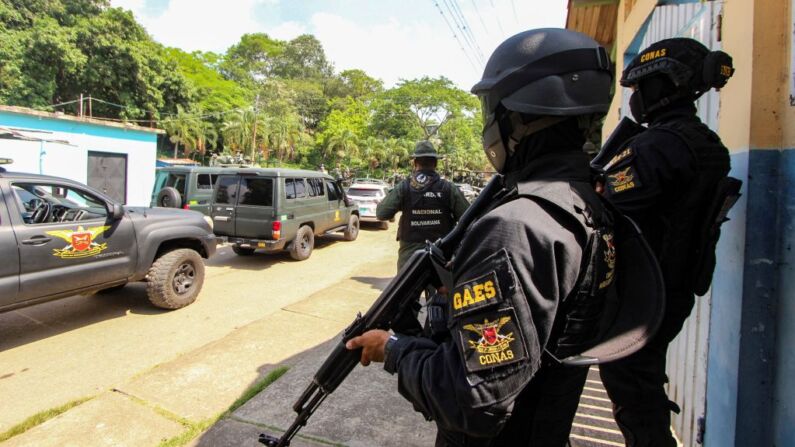 Miembros de la Guardia Nacional Bolivariana (GNB) y de la fuerza especial del Grupo Antiextorsión y Secuestro (CONAS) permanecen en un punto de control mientras son desplegados como parte de una operación militar, en Ureña, estado Táchira, Venezuela, el 13 de mayo de 2023. (JOHNNY PARRA/AFP vía Getty Images)