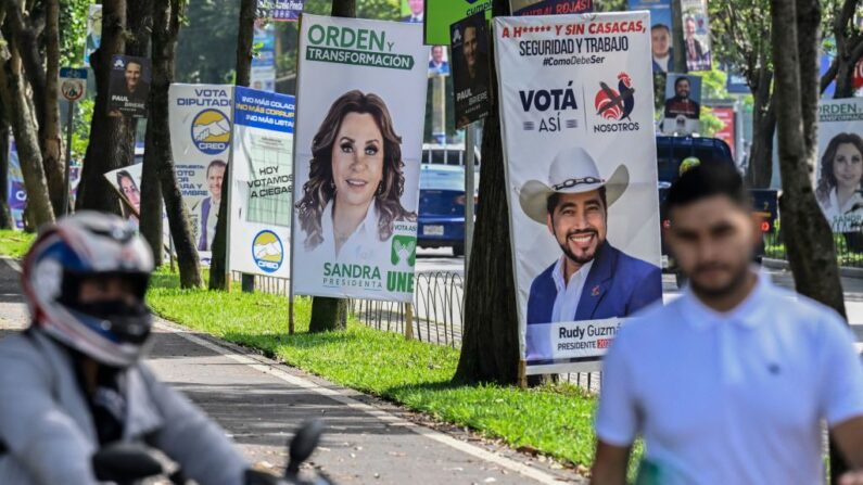 Un grupo de personas camina junto a las pancartas de los candidatos a las elecciones generales en Ciudad de Guatemala (Guatemala) el 22 de junio de 2023. (Luis Acosta/AFP vía Getty Images)