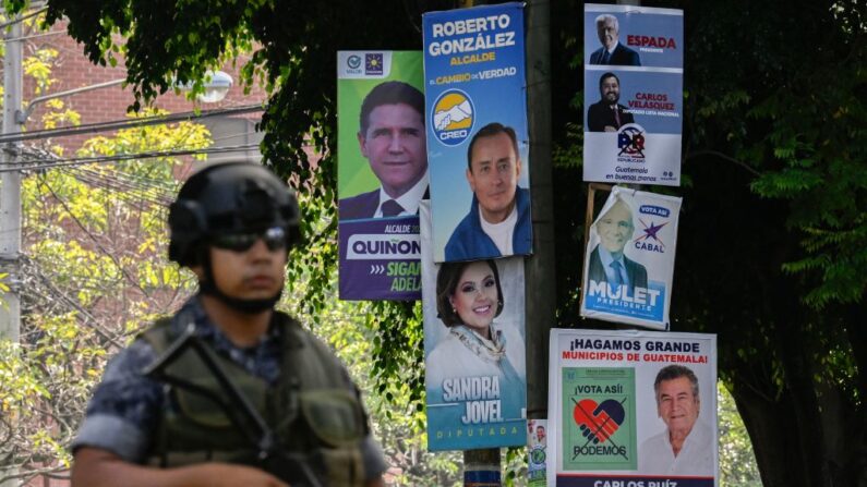 Un soldado de la Fuerza Aérea Guatemalteca patrulla cerca de anuncios políticos de candidatos a las elecciones generales en Ciudad de Guatemala (Guatemala) el 22 de junio de 2023. (Luis Acosta/AFP vía Getty Images)