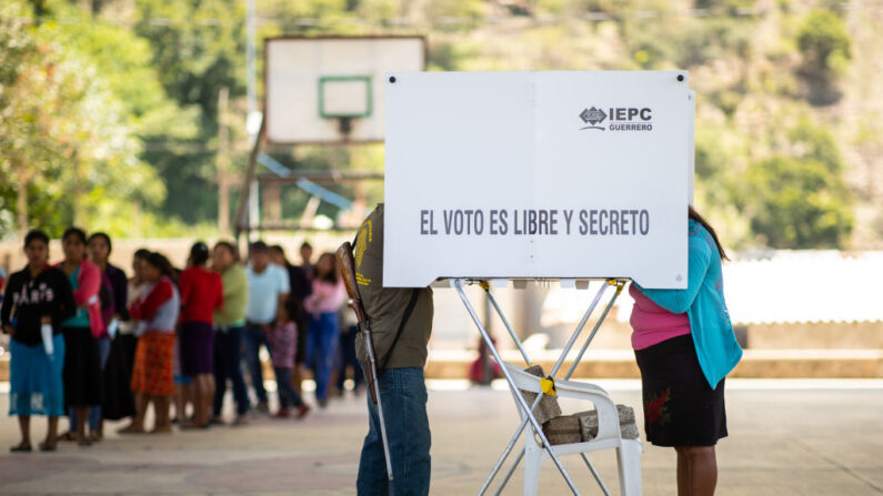 Un miembro del grupo de autodefensa CRAC emite su voto mientras porta un arma el 06 de junio de 2021 en Ayahualtempa, México. (Hector Vivas/Getty Images)