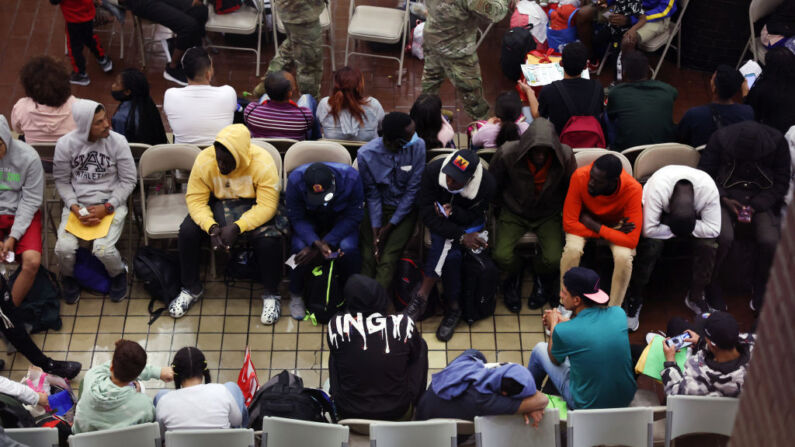 Solicitantes de asilo recién llegados esperan en una zona de espera de la terminal de autobuses de la Autoridad Portuaria antes de ser enviados a refugios y hoteles de la zona, el 15 de mayo de 2023 en Nueva York. (Spencer Platt/Getty Images)

