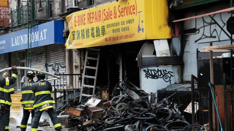 Los bomberos trabajan en el exterior de un edificio en Chinatown después de que cuatro personas murieran en un incendio en un taller de reparación de bicicletas eléctricas durante la noche del 20 de junio de 2023 en Nueva York. (Spencer Platt/Getty Images)