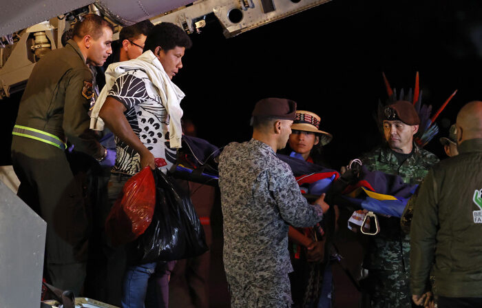 Fotografía del 9 de junio de Manuel Ranoque (2° de Izq.-Der.), padre de los menores Lesly Mukutuy, de 13 años; Soleiny Mukutuy, de 9; Tien Noriel Ronoque Mukutuy, de 4 años, y la bebé de un año Cristin Neruman Ranoque, ayuda a bajar del avión a uno de los niños a su llegada al Aeropuerto Militar de CATAM en Bogotá, Colombia. EFE/Mauricio Dueñas Castañeda