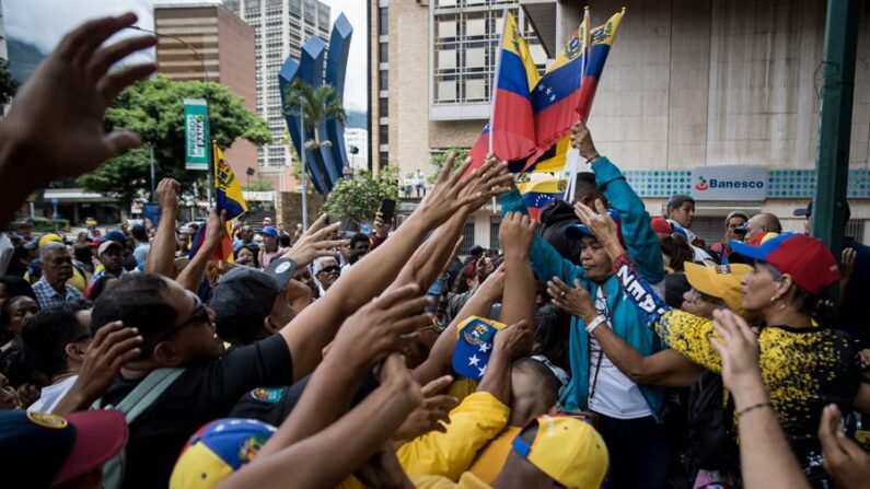 Seguidores de Henrique Capriles entregan banderas a los asistentes en un evento el 24 de junio de 2023, en Caracas (Venezuela). EFE/ Miguel Gutierrez
