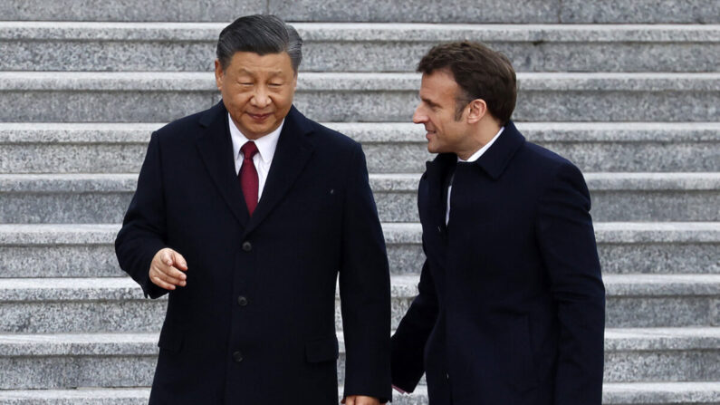 El líder del Partido Comunista Chino, Xi Jinping (izq.), conversa con su homólogo francés, Emmanuel Macron, a su llegada a la ceremonia de bienvenida en Beijing, el 6 de abril de 2023. (LUDOVIC MARIN/AFP vía Getty Images)