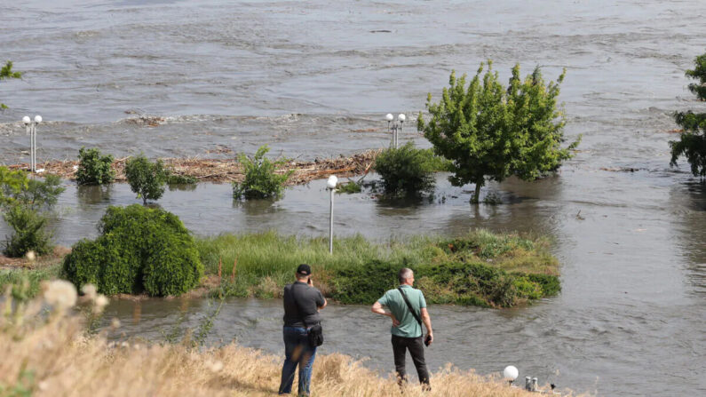 Los residentes locales miran un área parcialmente inundada de Kherson el 6 de junio de 2023, luego de los daños sufridos en la presa Kakhovka. La destrucción parcial desató un torrente de agua que envió a la gente a huir de las inundaciones en el frente de guerra. (Stringer/AFP vía Getty Images)
