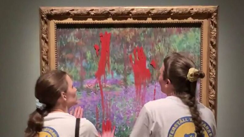 Dos activistas untan pintura en la obra de arte "El jardín del artista en Giverny" del pintor francés Claude Monet en el Museo Nacional de Estocolmo, Suecia, el 14 de junio de 2023. (Aterstall Vatmarker/Handout/AFP vía Getty Images)