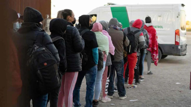 Extranjeros ilegales que solicitan asilo hacen fila para ser procesados ​​por agentes de la Aduana y la Patrulla Fronteriza de EE. UU. en un hueco en la valla fronteriza cerca de San Luis, Arizona, el 26 de diciembre de 2022. (Rebecca Noble/AFP vía Getty Images)