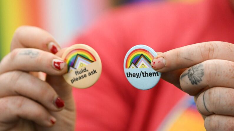 Un activista LGBT sostiene pins sobre los pronombres de género, en el campus de la Universidad de Wyoming en Laramie, Wyoming, el 13 de agosto de 2022. (Patrick T. Fallon/AFP vía Getty Images)
