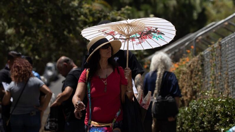 Una mujer se protege ante el sol y las altas temperaturas en el Echo Park de Los Ángeles, California (EE.UU.), el 15 de julio de 2023. EFE/Etienne Laurent