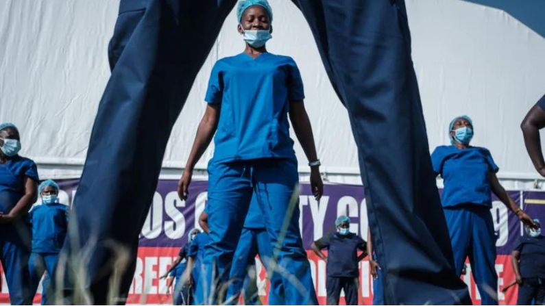 Los proveedores de atención médica (enfermeras, médicos, comadronas y trabajadores de la salud) asisten a la cuarta sesión de baile de Zumba organizada por el Consejo de Enfermería de Kenia en el estadio Kenyatta, donde se instalaron cabinas de detección y un hospital de campo de aislamiento para los casos del coronavirus COVID-19 en Machakos, Kenia, 19 de junio de 2020. Organización (OMS). (Foto de YASUYOSHI CHIBA/AFP vía Getty Images)