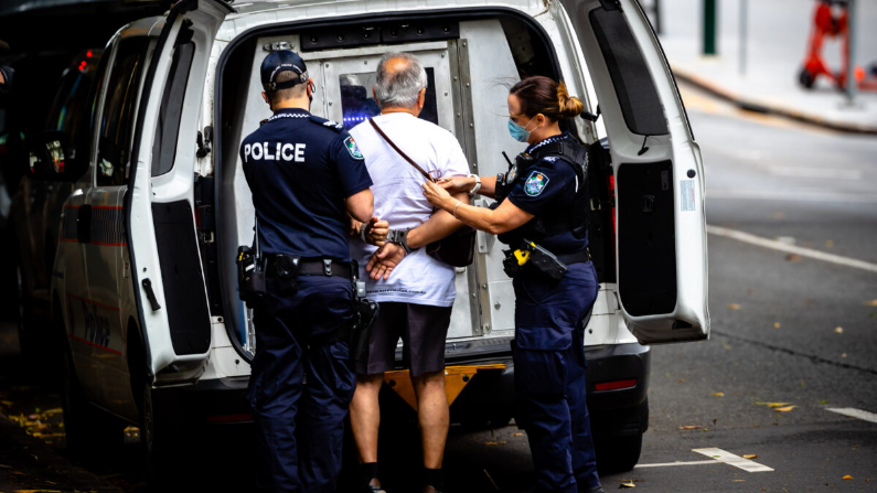 La policía detiene a un hombre por resistirse a llevar una mascarilla durante el primer día de cierre en Brisbane, Australia, el 9 de enero de 2021. (Patrick Hamilton/AFP vía Getty Images)