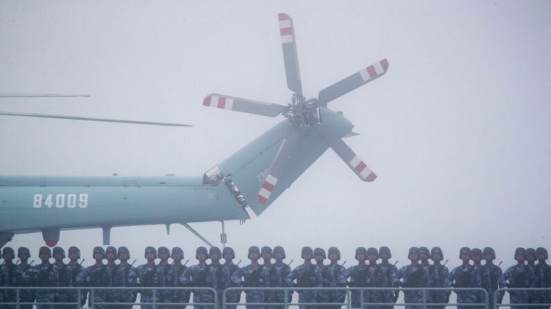 Soldados de pie en la cubierta del ambicioso muelle de transporte Yimen Shan de la Armada del Ejército Popular de Liberación (EPL) de China mientras participa en un desfile naval para conmemorar el 70 aniversario de la fundación de la Armada del EPL de China en el mar cerca de Qingdao, en la provincia oriental china de Shandong, el 23 de abril de 2019. (Mark Schiefelbein/AFP vía Getty Images)
