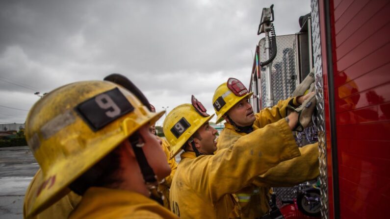 Los bomberos miran hacia arriba a los instrumentos de camiones de bomberos en una sesión de entrenamiento de la mañana del equipo LAFD Estación No9 en Skid Row el 12 de abril de 2020 en el centro de Los Ángeles, California. (Apu Gomes/AFP vía Getty Images)