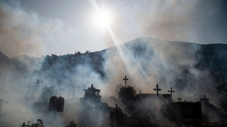 Especialistas fumigan el cementerio Nueva Esperanza contra los mosquitos Aedes que transmiten el dengue, así como el chikungunya y el zika, en las afueras de Lima, el 1 de junio de 2022. (ERNESTO BENAVIDES/AFP vía Getty Images)