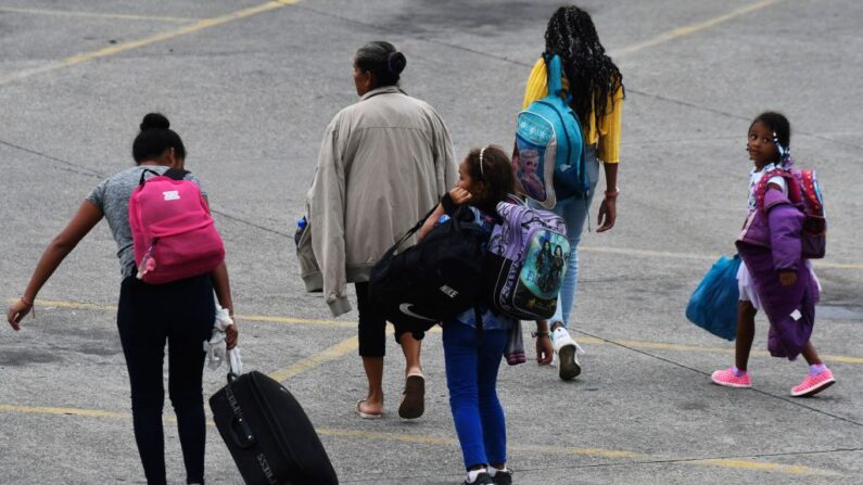 Una familia llega a la estación de autobuses Gran Central Metropolitana, desde donde la caravana migrante iniciará su camino hacia Estados Unidos en San Pedro Sula, Honduras, el 20 de octubre de 2022. (Orlando Sierra/AFP vía Getty Images)