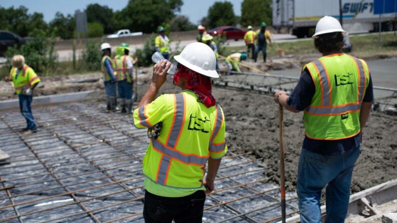 La inmigración ilegal afecta los salarios de los estadounidenses, según experto. En la imagen un trabajador de la construcción bebe un sorbo de agua mientras repara una carretera dañada por el calor en Houston, Texas, el 27 de junio de 2023. (MARK FELIX/AFP vía Getty Images)