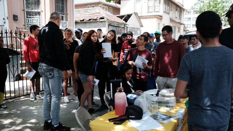 Solicitantes de asilo recién llegados reciben información sobre asistencia sanitaria gratuita delante del colegio P.S. 188 de Coney Island, que recientemente ha empezado a alojar a inmigrantes en el gimnasio del colegio, el 16 de mayo de 2023 en Nueva York. (Spencer Platt/Getty Images)