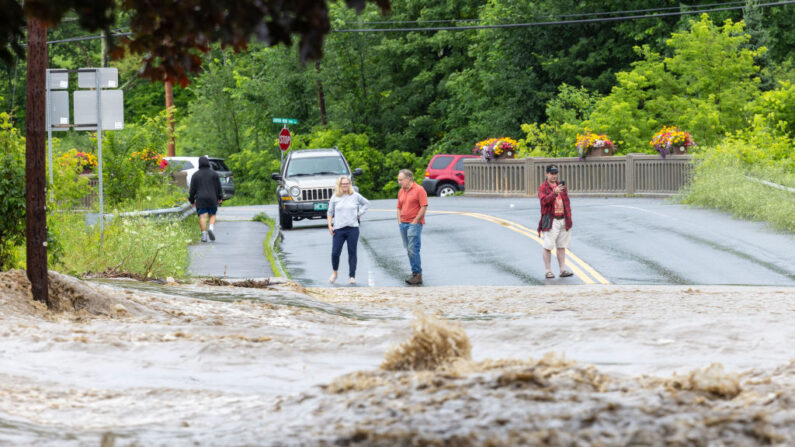 Los vecinos observan una carretera inundada el 10 de julio de 2023 en Chester, Vermont.  (Scott Eisen/Getty Images)