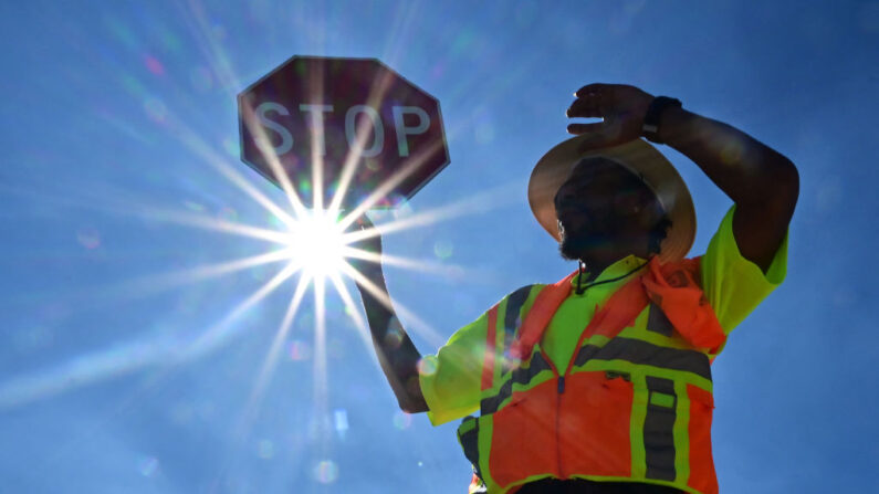 El guardia de tráfico Rai Rogers vigila la esquina de su calle durante un turno de 8 horas bajo un sol abrasador en Las Vegas, Nevada (EE.UU.), el 12 de julio de 2023, donde las temperaturas alcanzaron los 106 grados Fahrenheit en medio de una ola de calor. (Frederic J. Brown/AFP vía Getty Images)