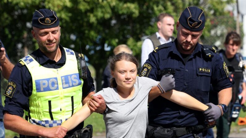 La activista climática Greta Thunberg es llevada en brazos por agentes de policía tras participar en una nueva acción climática en Oljehamnen, en Malmo (Suecia), el 24 de julio de 2023, poco después de que el tribunal de distrito de la ciudad la declarara culpable y la condenara a pagar una multa por desobedecer a la policía en una concentración el mes pasado durante una acción climática en el barrio de Norra hamnen de Malmo. (Andreas Hillergren/Agencia de Noticias TT/AFP vía Getty Images)