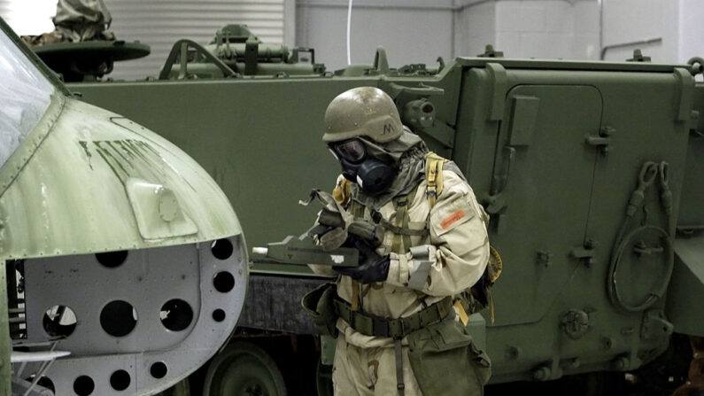 Un soldado del Ejército de EE. UU. utiliza un monitor de agentes químicos (CAM) para tratar de detectar agentes nerviosos en la sección frontal de un helicóptero mientras se entrena en una escuela química el 18 de abril de 2003 en Fort Leonard Wood, Missouri. (Brendan Smialowski/Getty Images)