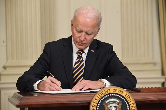 El presidente Joe Biden firma una orden ejecutiva en el Comedor de Estado de la Casa Blanca en Washington el 24 de febrero de 2021. (Saul Loeb/AFP vía Getty Images)