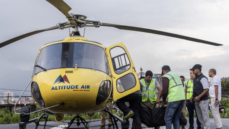 Personal de las aerolíneas nepalesas y policías llevan los cuerpos de las víctimas, tras el accidente de un helicóptero de Manang Air, en el helipuerto del Hospital Docente de Katmandú, Nepal, 11 de julio de 2023. EFE/EPA/Narendra Shrestha 