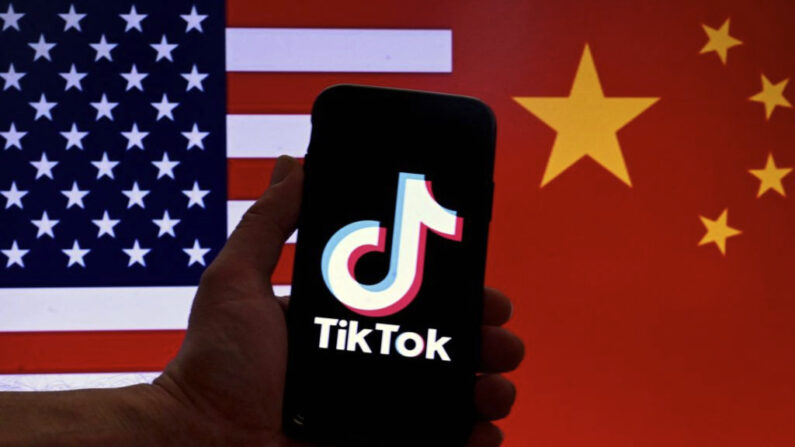 El logotipo de la aplicación de redes sociales TikTok se muestra en la pantalla de un iPhone ante un fondo de banderas de Estados Unidos y China, en Washington, el 16 de marzo de 2023. (Olivier Douliery/AFP vía Getty Images)