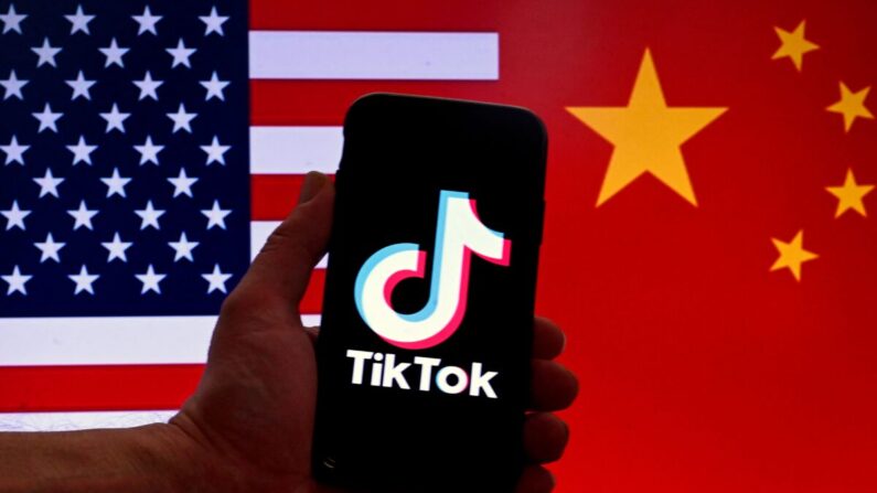 El logotipo de la aplicación de redes sociales TikTok se muestra en la pantalla de un iPhone frente a una bandera estadounidense y una bandera china en Washington, el 16 de marzo de 2023. (Olivier Douliery/AFP vía Getty Images)