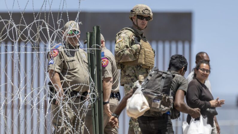 Un soldado de la Guardia Nacional de Texas observa cómo un inmigrante ilegal entra en un campamento improvisado en El Paso, Texas, el 11 de mayo de 2023. (John Moore/Getty Images)
