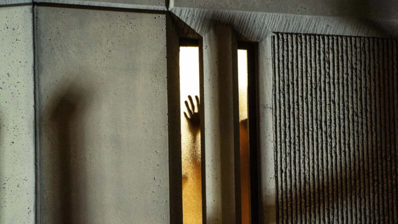Una persona coloca su mano en una ventana dentro de una cárcel en Tacoma, Washington, el 24 de enero de 2021. (David Ryder/Getty Images)