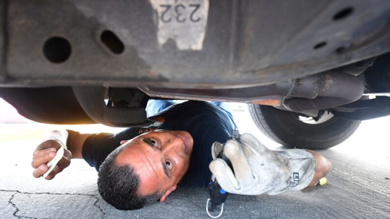 El ayudante Jaime Moran, del Departamento del Sheriff de Los Ángeles, graba el catalizador de un vehículo con un número rastreable en City of Industry, California, el 14 de julio de 2021. (Frederic J. Brown/AFP vía Getty Images)