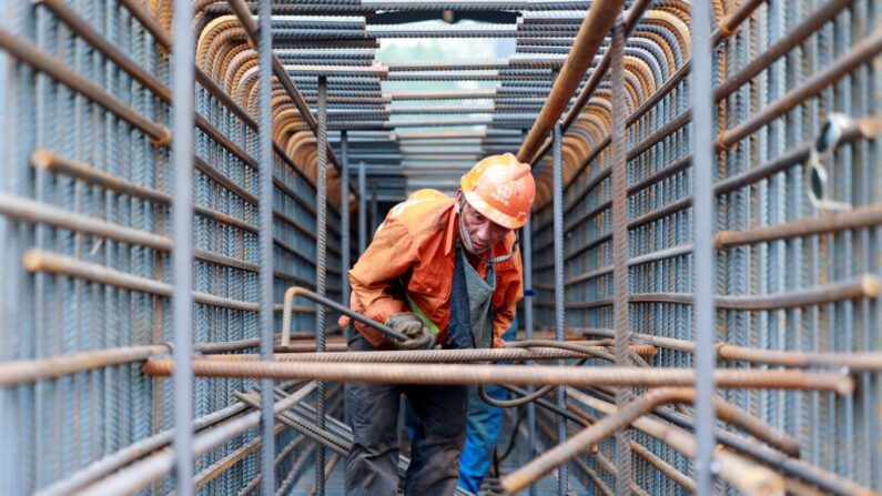 Un trabajador prepara barras de acero en la obra del puente Zhangjinggao sobre el río Yangtsé en la isla de Mazhou en Jingjiang, en la provincia oriental china de Jiangsu, el 14 de julio de 2023. (STRINGER/AFP vía Getty Images)