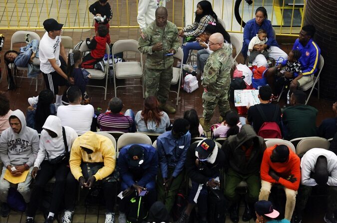 Inmigrantes ilegales recién llegados esperan en una zona de espera de la terminal de autobuses de la Autoridad Portuaria antes de ser enviados a albergues y hoteles de la zona, en Nueva York, el 15 de mayo de 2023.(Spencer Platt/Getty Images)