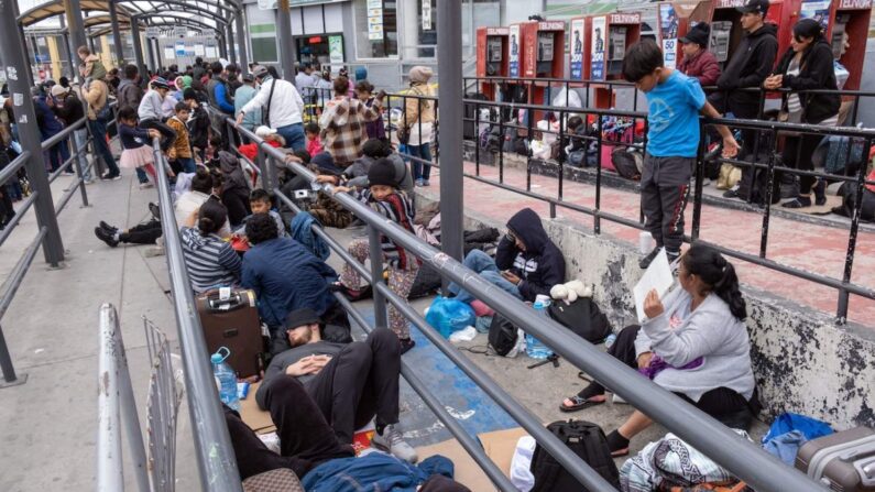 Migrantes que solicitan asilo esperan a que los agentes de Aduanas y Protección Fronteriza de EE. UU. les permitan entrar en Estados Unidos en el puerto de cruce de San Ysidro, en la frontera entre EE. UU. y México, visto desde Tijuana, estado de Baja California, México, el 31 de mayo de 2023. (Guillermo Arias/AFP vía Getty Images)
