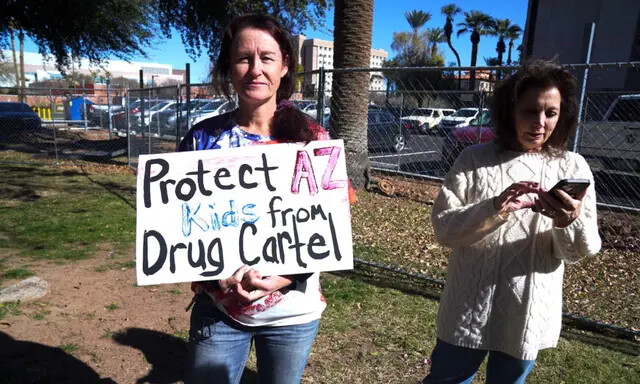 La socorrista y paramédica Carley Morgan sostiene un cartel que protesta contra los cárteles mexicanos de la droga en una conferencia de prensa sobre la crisis fronteriza, en Phoenix, el 26 de enero de 2023. (Allan Stein/The Epoch Times)
