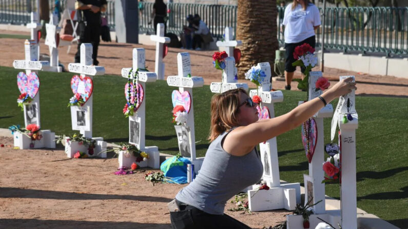 Ashley Schuck, de Nevada, coloca una medalla en una cruz que conmemora a Neysa Tonks, una de las victimas del tiroteo masivo en un concierto de 2017 en Las Vegas, Nevada, el 1 de octubre de 2018. (Ethan Miller/Getty Images)
