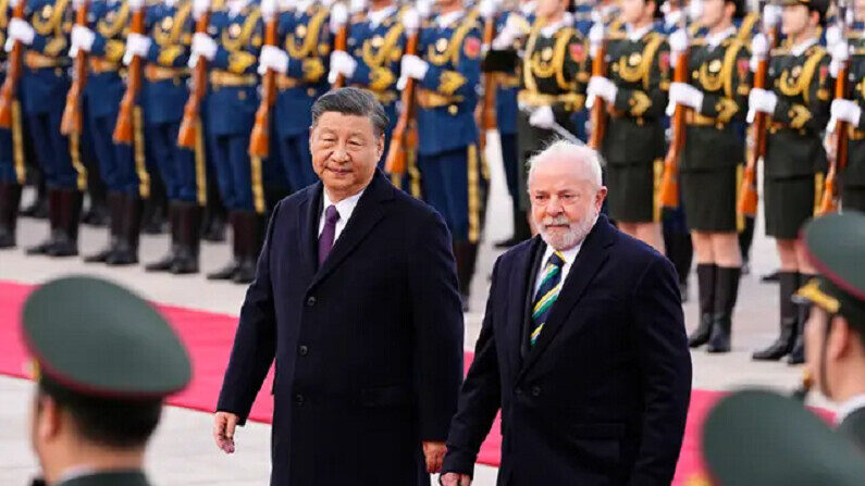 El presidente brasileño Luiz Inacio Lula da Silva se une al líder chino Xi Jinping en la inspección de tropas durante una ceremonia de bienvenida ante el Gran Salón del Pueblo en Pekín el 14 de abril de 2023. (Ken Ishii/Pool/Getty Images)
