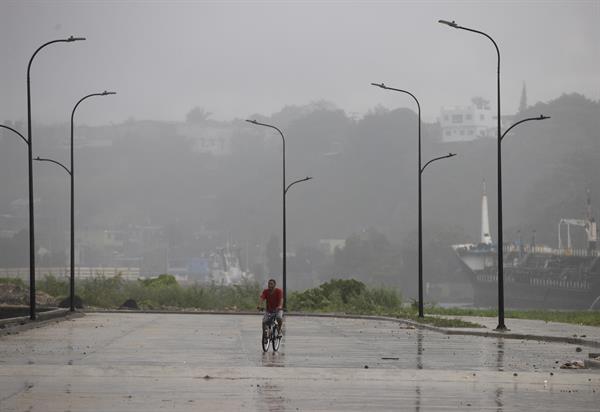 Un hombre conduce su bicicleta bajo la lluvia debido al paso de la tormenta tropical Franklin, en Santo Domingo (República Dominicana). EFE/Orlando Barría
