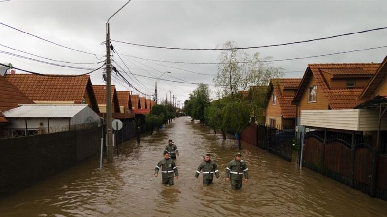 Rescatistas caminan por una calle inundada tras el desborde del río Claro, en la ciudad de Talca (Chile). EFE/ Rafael Arancibia