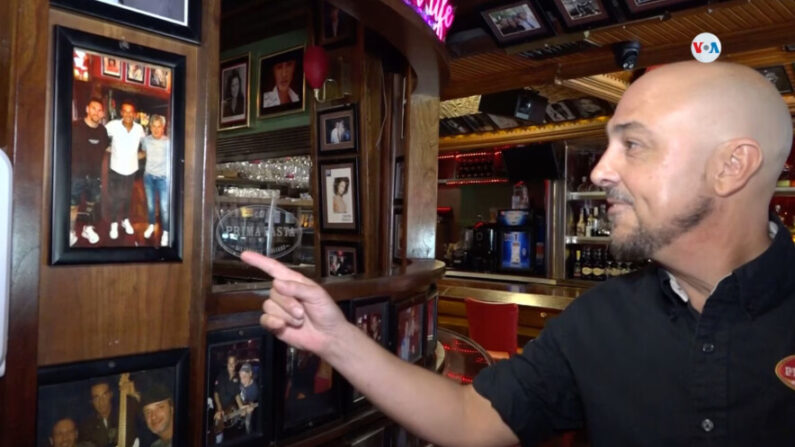 El responsable del bar "Café Prima Pasta" en Miami Beach, Florida, enseña una de las fotografías expuestas en el negocio durante una visita de Leo Messi. VOA/Antoni Belchi