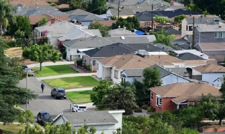 Un hombre camina por una calle de un barrio de casas unifamiliares de Los Ángeles el 30 de julio de 2021. (Frederic J. Brown/AFP vía Getty Images)