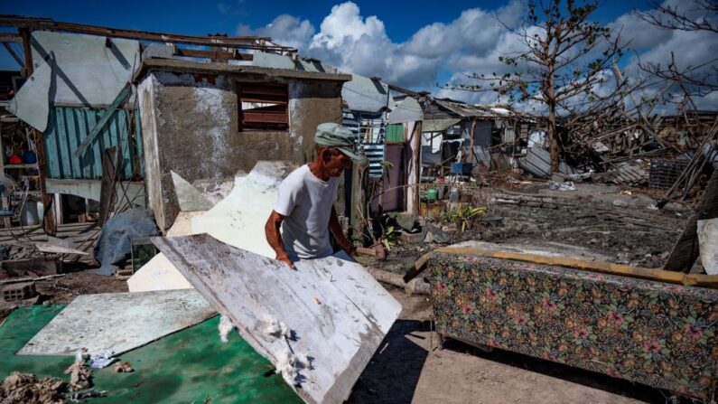 Un hombre intenta recuperar material dañado durante el huracán Ian en La Coloma, en la provincia de Pinar del Río, Cuba, el 13 de octubre de 2022. (Yamil Lage/AFP vía Getty Images)