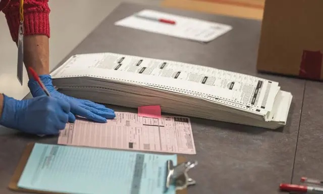 Un trabajador electoral manipula papeletas en Arizona, el 25 de octubre de 2022. (Olivier Touron/AFP vía Getty Images)