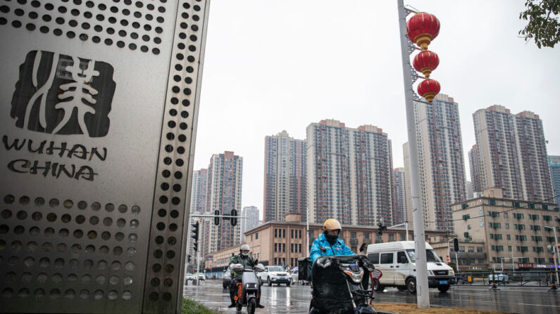 Personas con mascarillas recorren una calle frente a un mercado de marisco cerrado de Huanan el 23 de enero de 2022, en Wuhan, China. (Getty Images)