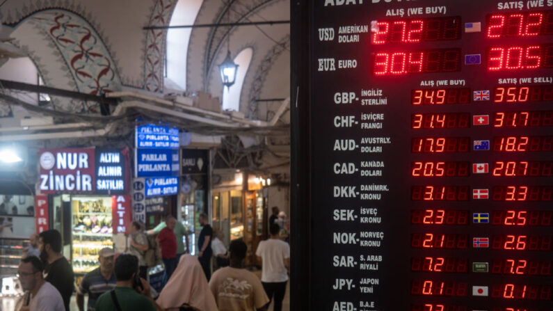 Un grupo de personas pasa junto a un panel de cambio de divisas en el famoso Gran Bazar de Estambul el 19 de julio de 2023 en Estambul, Turquía. (Chris McGrath/Getty Images)